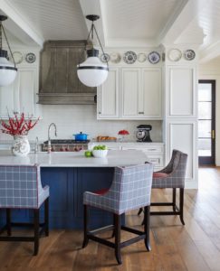 Montrose Metal Range Hood with white cabinets and a blue kitchen island surrounded by chairs