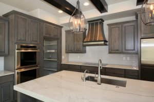 Montrose Metal Range Hood with gray cabinets and white countertops