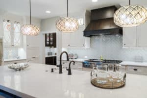 Creede Metal Range Hood with white cabinets and globe lights