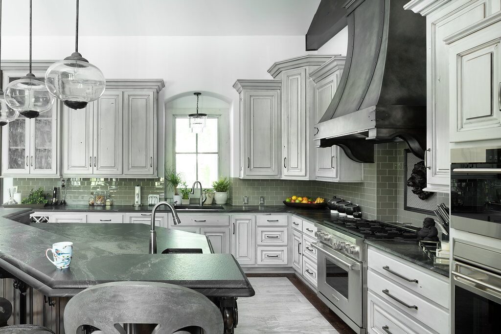White kitchen with gray details with two toned antique steel vent hood
