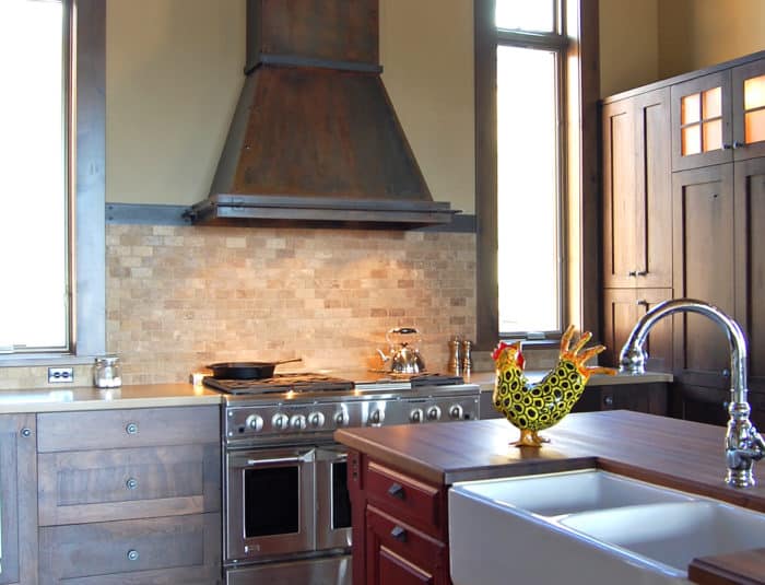 Sanctuary Design features our rustic Breckenridge range hood for high ceilings in Rustic Iron finish.