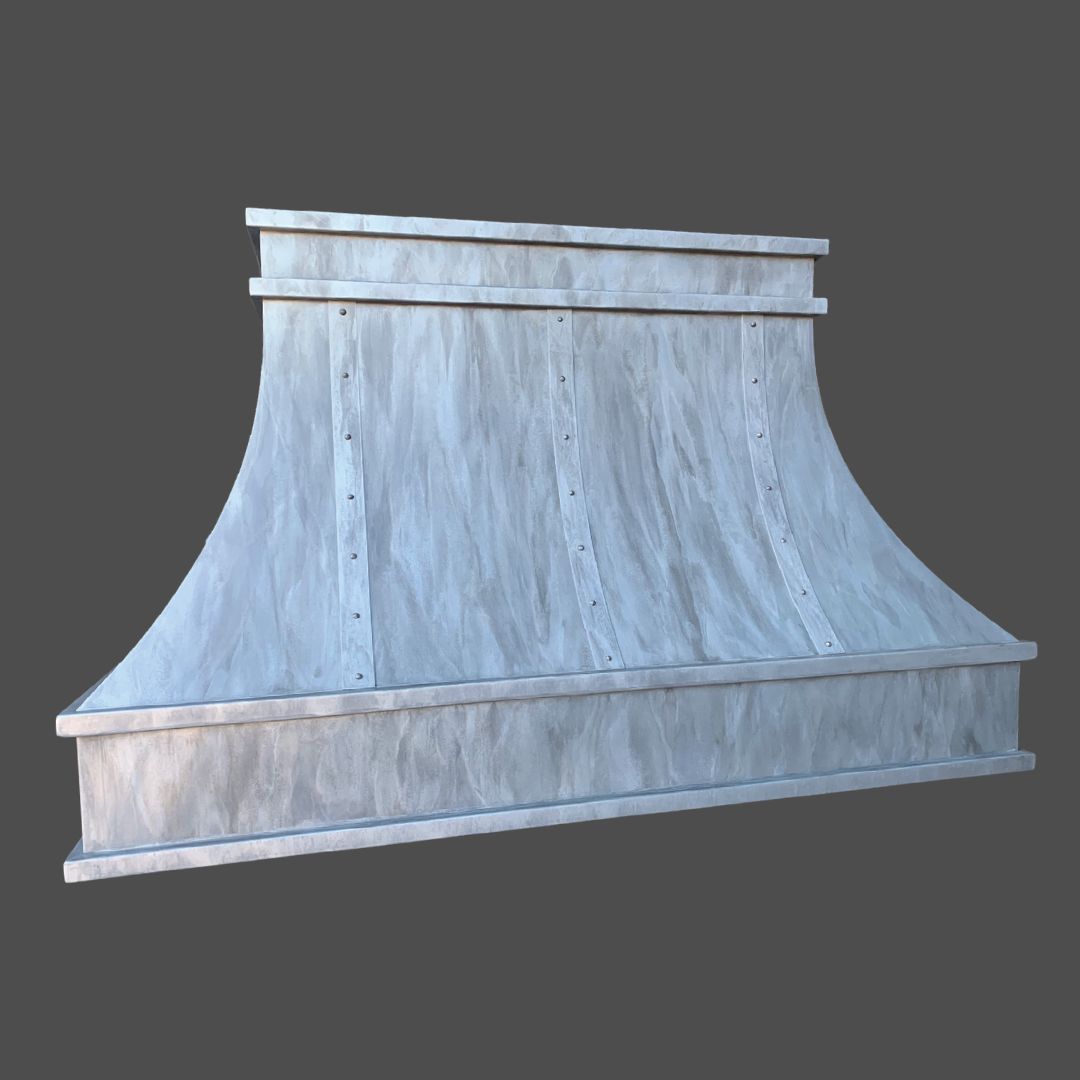 Zinc Washed 3 The Zinc Washed 3 is a metallic, curved range hood with a brushed silver finish, vertical panels, and decorative trim on the top and bottom, set against a plain dark background.