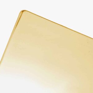 A close-up of the corner of a thin, rectangular Polished Brass sheet set against a light background.