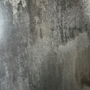 A close-up of Rustic Reclaimed, featuring a textured, weathered concrete wall with varied gray tones, dark streaks, and rough, uneven surfaces.