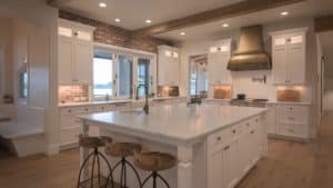 white kitchen with gold brass vent hood in antique finish