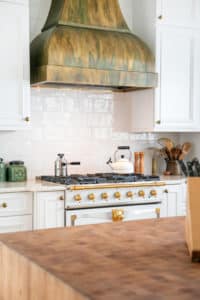 Bonner Peak Metal Range Hood with white cabinets and stove