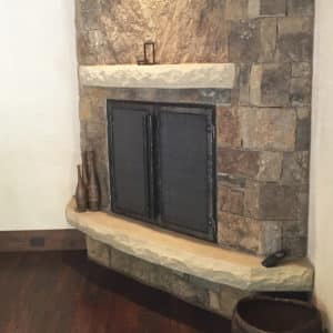 Antique fireplace with a stone backdrop