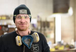 man posing with safety glasses, beanie, and air filter