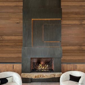 The Cladding product image showcases a contemporary fireplace with a geometric metal design and glowing embers, set against wood paneling. Two white chairs featuring black armrests are positioned on either side.
