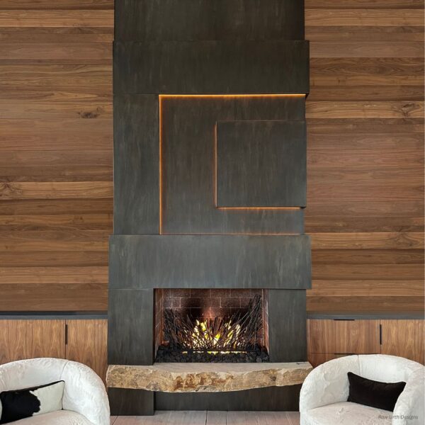 The Cladding product image showcases a contemporary fireplace with a geometric metal design and glowing embers, set against wood paneling. Two white chairs featuring black armrests are positioned on either side.
