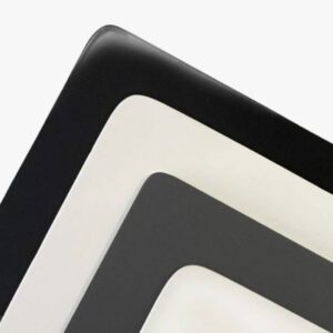 Close-up of corners of three stacked rectangular trays painted with Enamel Paint in black, white, and gray, arranged diagonally on a white background.