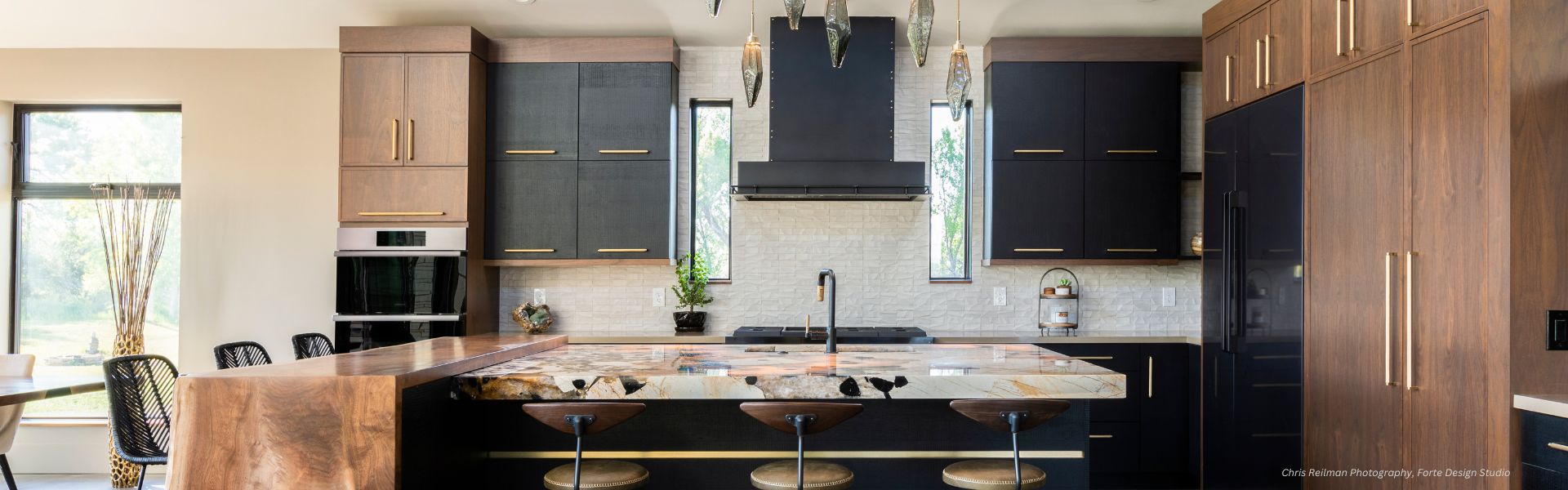 Discover the modern-kitchen-black-hood featuring dark cabinets, marble countertops, and elegant wooden accents. The island boasts a unique veining pattern with three wooden bar stools. Tall windows and pendant lights enhance the bright and airy ambiance.