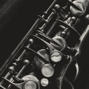 A black-and-white close-up of detailed metal keys and mechanisms on the Antique 2 woodwind instrument, set against a dark background.