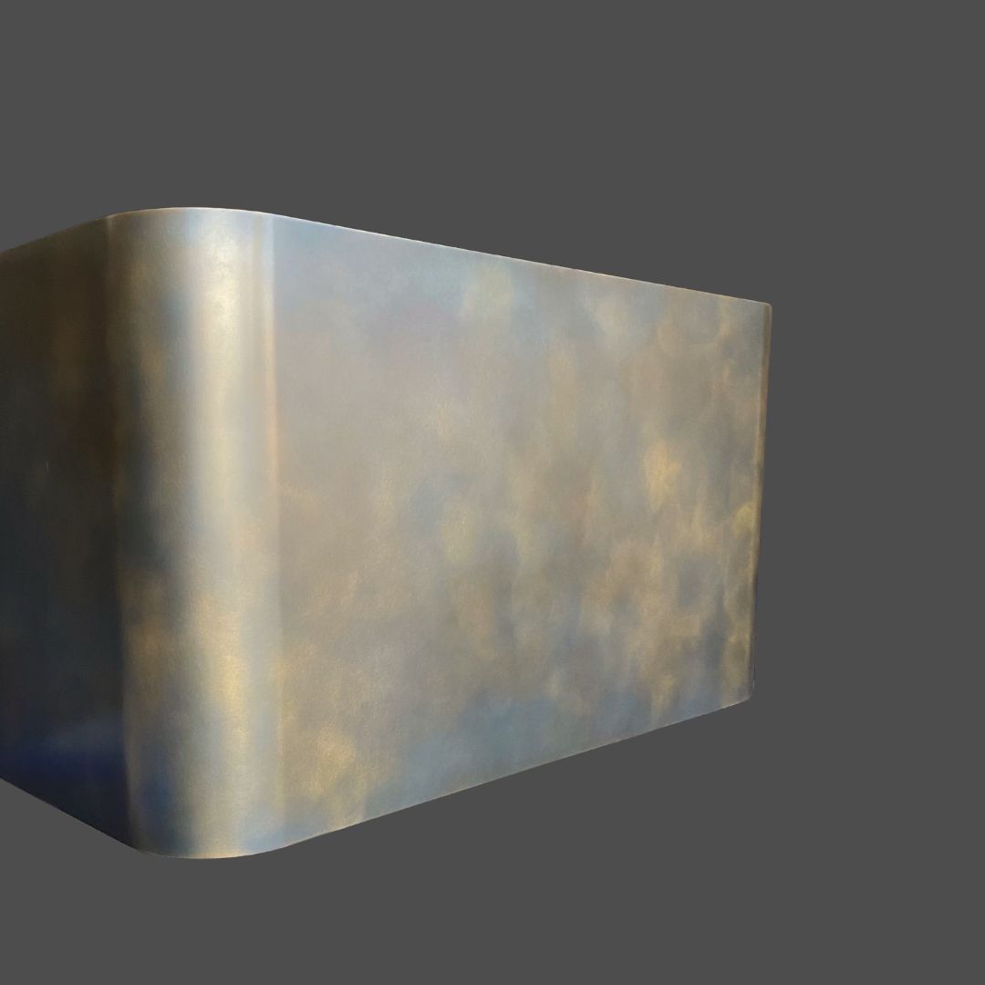 Brass Antique 3, a rectangular metallic object with rounded edges and a reflective, cloudy surface finish, is set against a plain gray background.