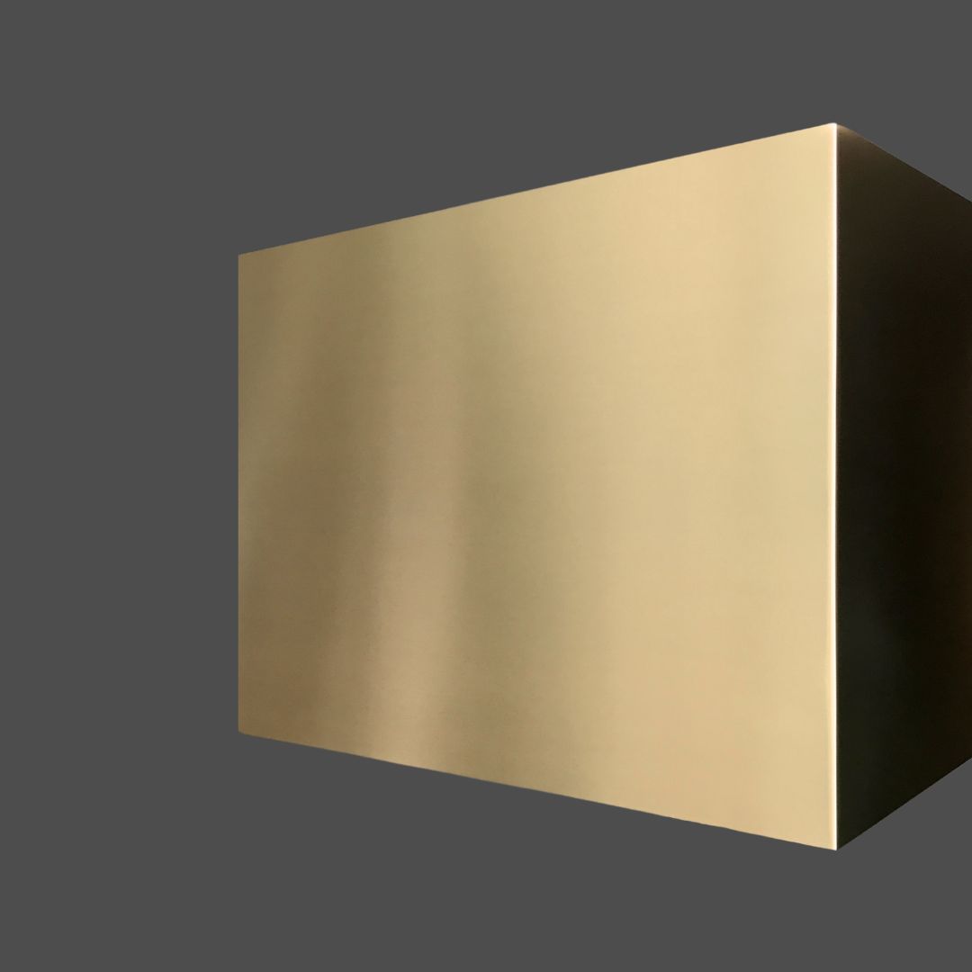Brass Burnished 1-2 The Brass Burnished 1-2, a large rectangular metallic box with a smooth matte gold finish, floats against a dark gray background, its surface softly reflecting light.