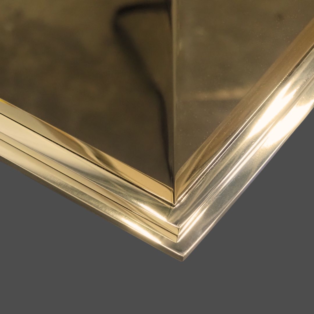 Brass Polished 1 Close-up of the Brass Polished 1 picture frame’s shiny, gold-finished corner reflecting light with smooth, clean lines. The background is blurred and dark.
