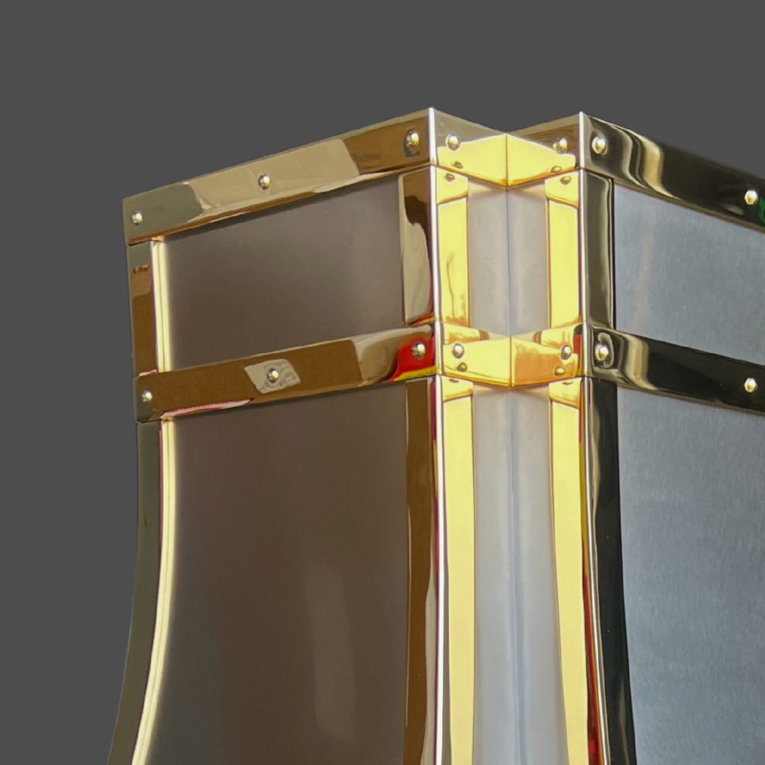 Brass Polished 3 Close-up of Brass Polished 3, a modern metallic structure featuring shiny gold and silver finishes, riveted panels, and smooth reflective surfaces against a plain gray background.