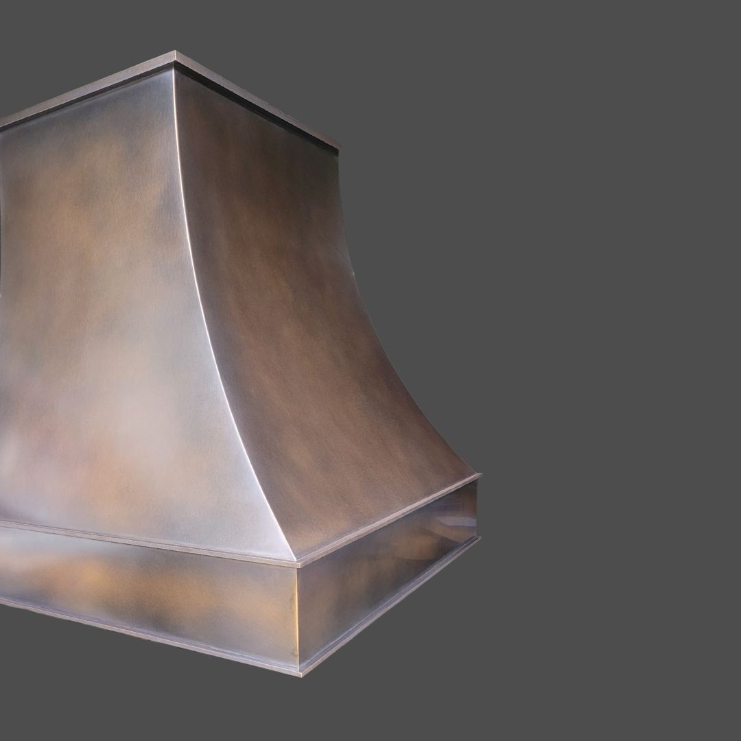 Bronze Antique 1 The Bronze Antique 1 is a metallic, rectangular range hood with smooth curved sides and a brushed finish, displayed against a plain gray background.