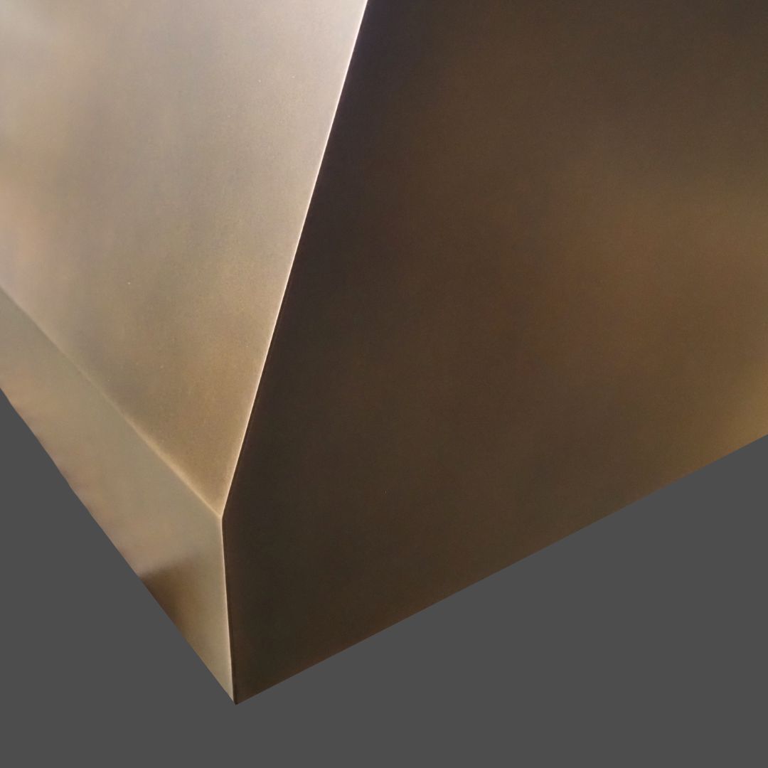 Bronze Antique 3 Close-up view of the Bronze Antique 3—a smooth, metallic geometric structure with sharp edges and angular surfaces, set against a plain, dark background.