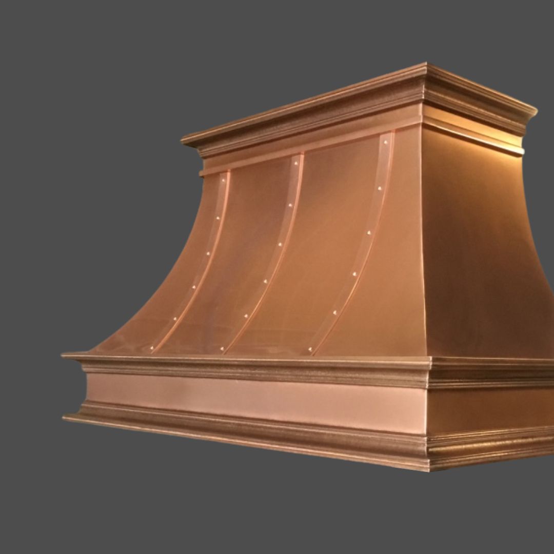 Copper Burnished 1 The Copper Burnished 1 kitchen range hood features a curved design with riveted panels, showcased against a plain grey background.