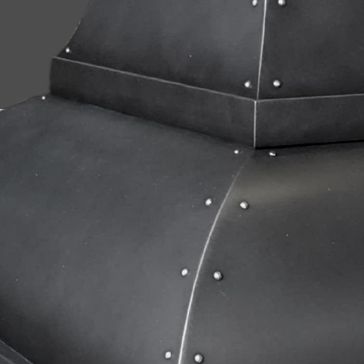 Dark Antique 3 Close-up of Dark Antique 3’s matte black metal surface with visible seams and round rivets, highlighting its geometric structure with angled sections and joints.