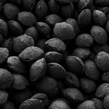Dark Antique 6 A close-up image of numerous small, round, black Dark Antique 6 briquettes tightly packed together, filling the entire frame.