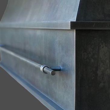 Close-up view of the Gunmetal 4 metallic surface featuring a horizontal rod, likely part of industrial equipment or a modern architectural element, set against a plain gray background.