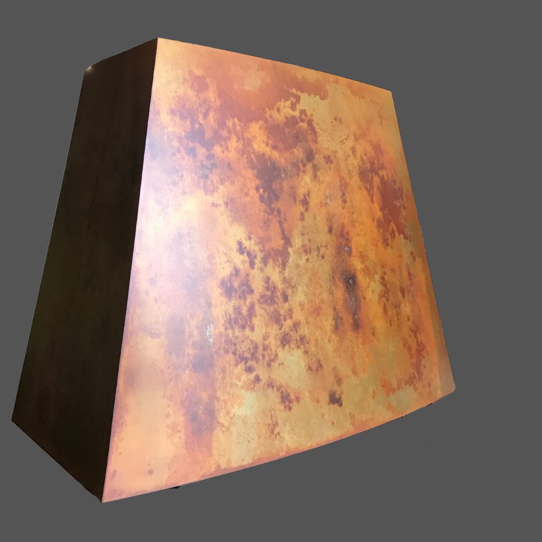 Leathered 3 Leathered 3: A trapezoidal metal object with a rusty, weathered surface featuring orange, brown, and yellow patches on a plain gray background.