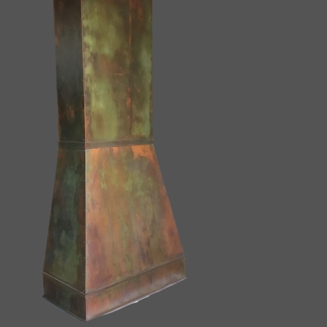 Penny Iron 3 The Penny Iron 3 is a tall, metallic, cone-shaped hood with a weathered multicolored patina finish in green, brown, and orange tones, shown against a plain gray background.