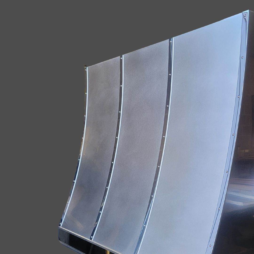 Pewter Burnished 3: A curved, metallic four-panel structure with evenly spaced vertical seams and visible rivets, featuring a smooth, reflective surface against a plain gray background.