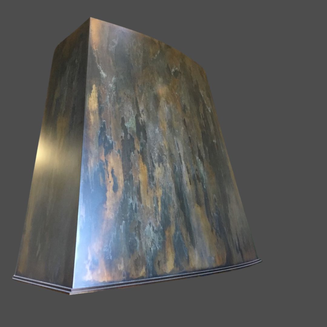 Rustic Reclaimed 1 The Rustic Reclaimed 1 is a trapezoidal metal range hood with a weathered, rusted finish, displayed against a plain gray background.