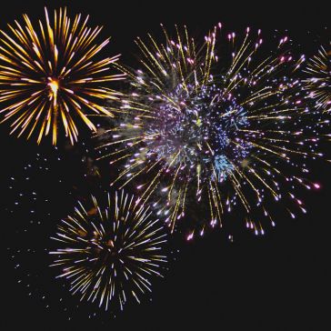Rustic Reclaimed 5 Colorful fireworks burst against a dark night sky, featuring the Rustic Reclaimed 5 with yellow, white, and purple explosions radiating outward in various patterns.