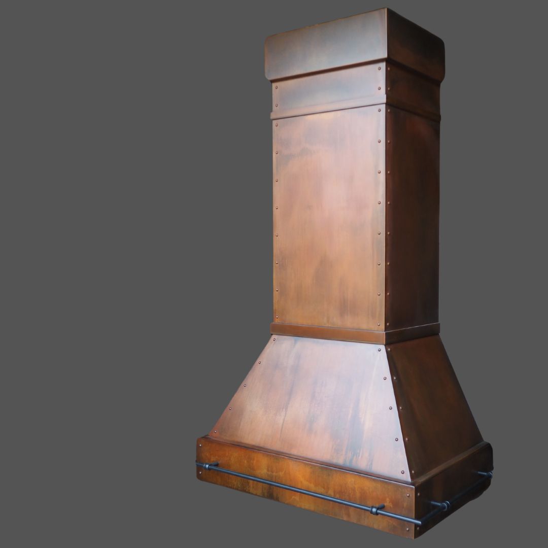 Rusty Rustic Iron 1 The Rusty Rustic Iron 1 is a large, rectangular copper range hood featuring a wide base, tall straight chimney, polished warm brown finish with visible rivets, and black metal rods on the lower section—shown against a plain gray background.