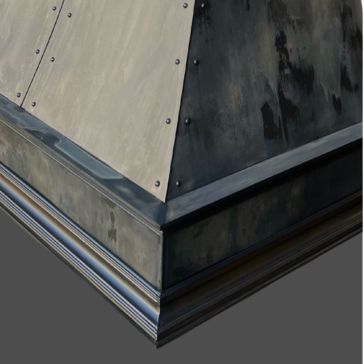 A close-up of Showroom Reclaimed 1, featuring metal-clad riveted panels and a layered trim base, set against a plain gray background.