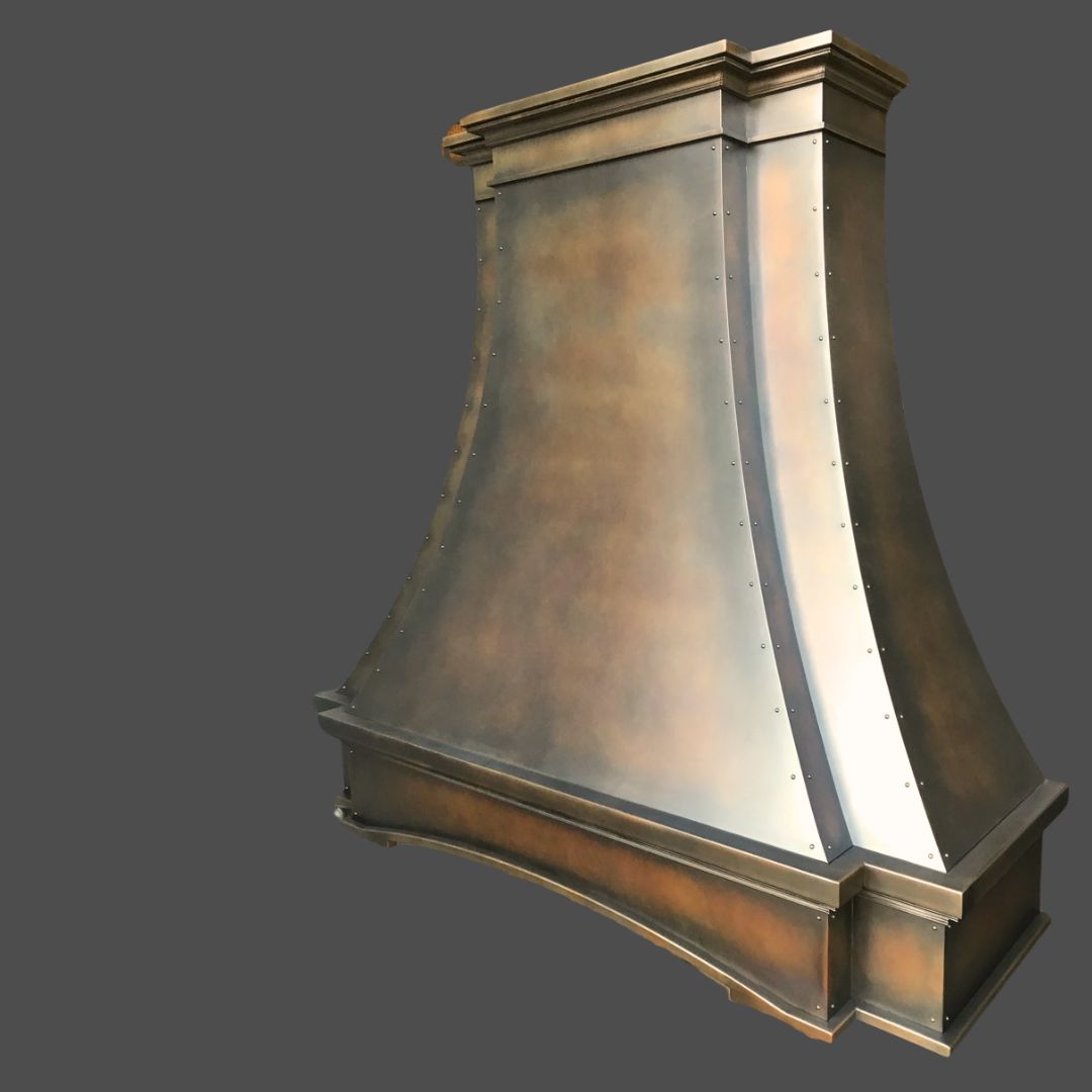 The Warm Foundry 1 is a large metal range hood featuring a flared, curved design with rivet details and a bronze, slightly mottled finish, shown against a plain gray background.