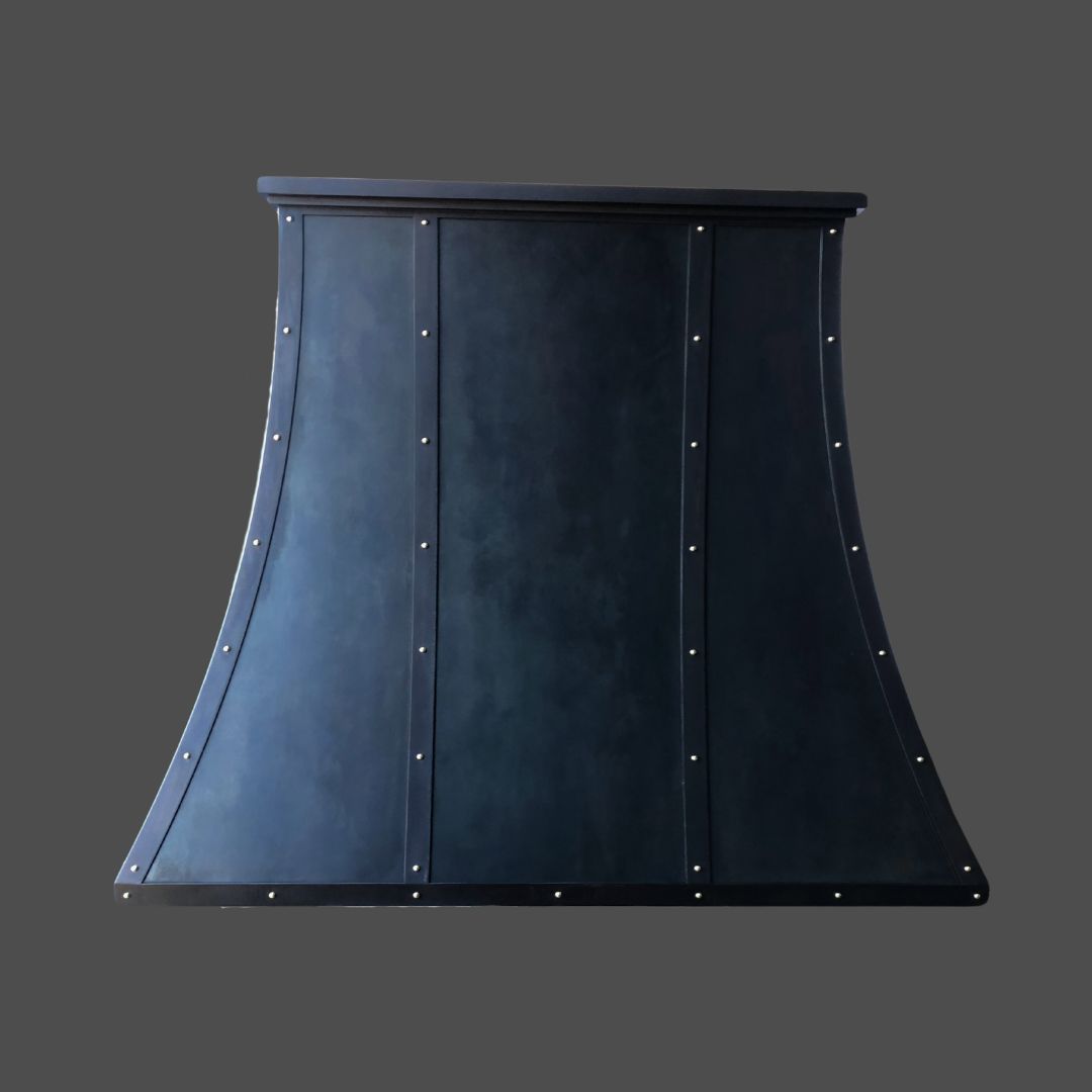 Winter Blue 1: A dark, matte-finished flared range hood featuring vertical paneling and evenly spaced rivets, displayed against a plain gray background.