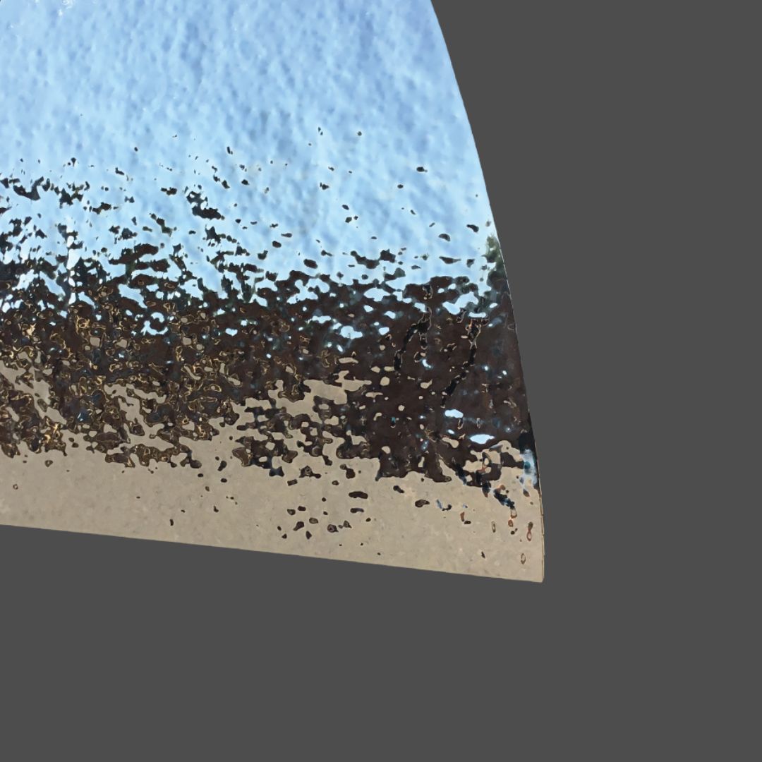 Zinc Polished 1 The Zinc Polished 1 features a curved glass fragment with a textured edge, reflecting blue skies, brown landscapes, and pale ground tones against a plain gray background.