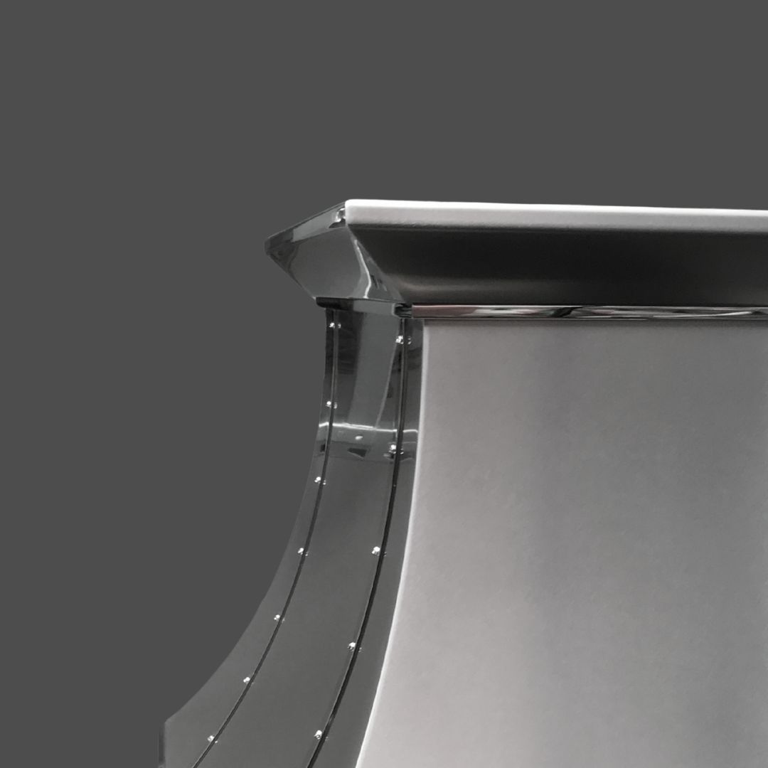 Zinc Polished 3-2 Close-up of the Zinc Polished 3-2 range hood featuring a sleek, modern metallic finish, curved design, and rivet details, set against a solid gray background.