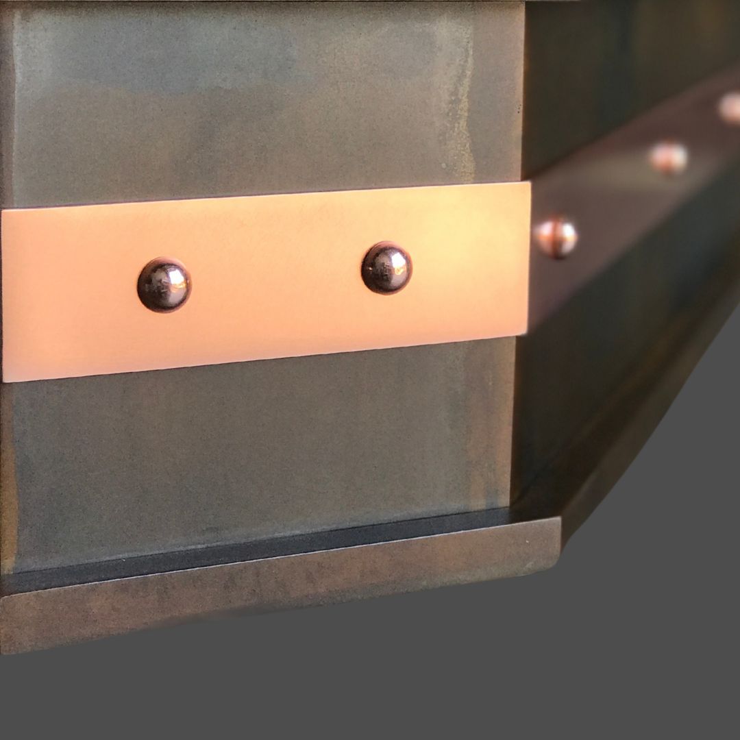 Copper Polished 2 Close-up of Copper Polished 2’s matte metallic surface, showcasing a horizontal copper strip with evenly spaced round rivets against a solid dark gray background.