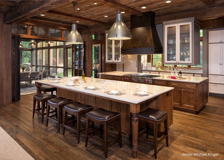 ru-creede The ru-creede features a rustic kitchen with wooden floors, exposed beams, a spacious island seating five, pendant lighting, modern appliances, and expansive windows for abundant natural light.