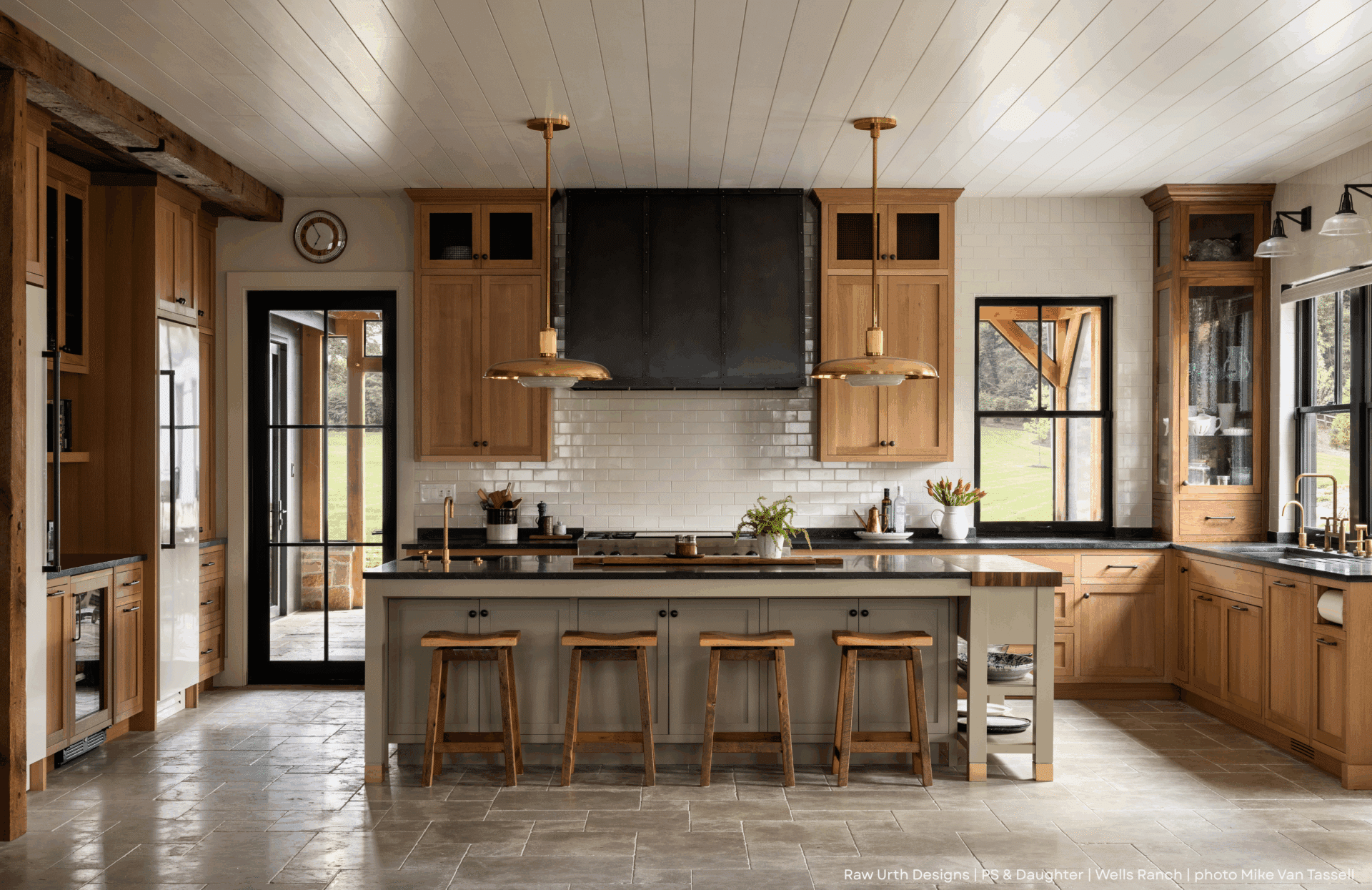 Kitchen Product Name: 6 features light wood cabinets, a large island with stools, black countertops, white subway tile backsplash, pendant lights, and big windows for plenty of natural light.
